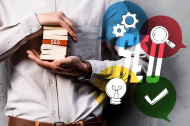 cropped view of seo manager holding wooden rectangles and standing near seo illustration clipart