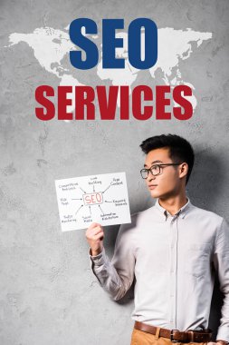 asian seo manager holding paper with concept words of seo and standing near seo services illustration clipart