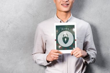 GDPR illüstrasyonlu dijital tablet tutan gülümseyen işadamının kırpılmış görüntüsü 
