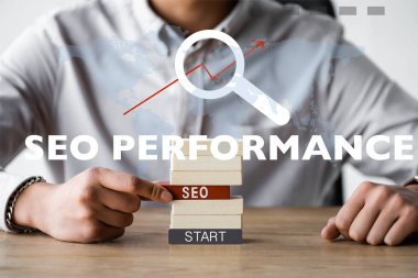seo harflerle dikdörtgen tutan ve seo performans illüstrasyonunun yanında oturan seo yöneticisinin kırpılmış görünümü 