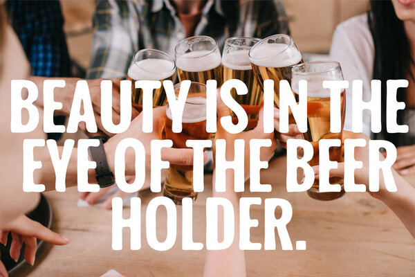 cropped view of multicultural friends clinking glasses of beer near beauty is in the eye of the beer holder illustration