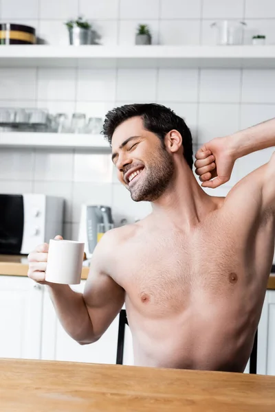 Happy Shirtless Man Stretching Holding Cup Coffee Kitchen Morning — Stock Photo, Image