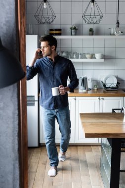 Karantina sırasında cep telefonuyla konuşan düşünceli bir adam.  