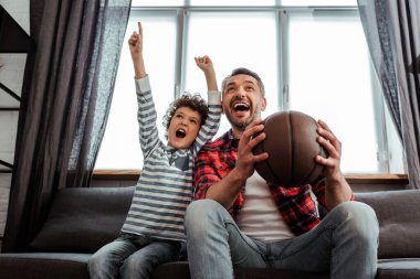 heyecanlı çocuk ve baba basketbol oynarken şampiyonluğu izliyorlar. 