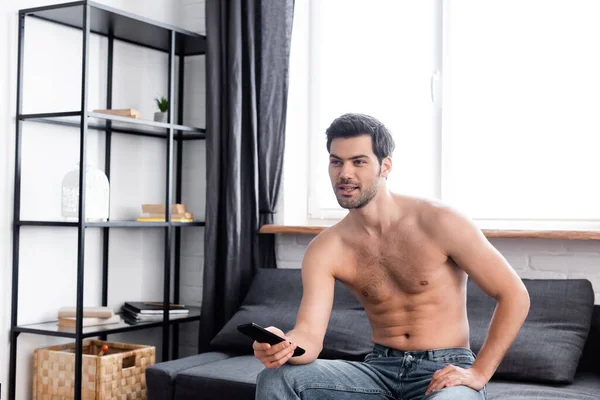 Hombre Sin Camisa Sexy Positivo Sosteniendo Mando Distancia Mientras Televisión — Foto de Stock