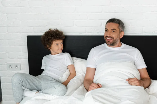 Curly Boy Looking Bearded Father Bedroom — Stock Photo, Image