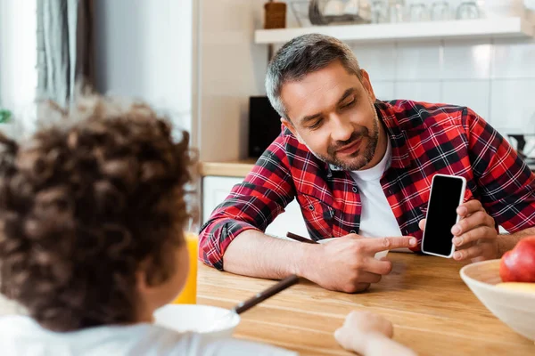 Enfoque Selectivo Padre Guapo Señalando Con Dedo Teléfono Inteligente Con — Foto de Stock