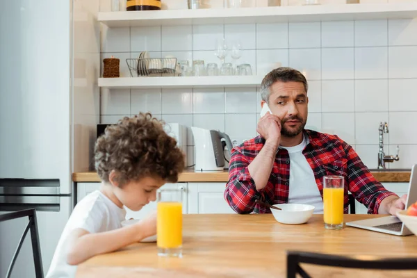 Enfoque Selectivo Freelancer Padre Hablando Teléfono Inteligente Mirando Rizado Hijo — Foto de Stock