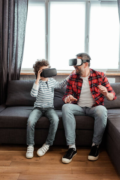 bearded father and cute son in virtual reality headsets 