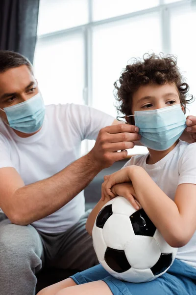 Pai Carinhoso Vestindo Máscara Médica Filho Encaracolado Com Futebol — Fotografia de Stock