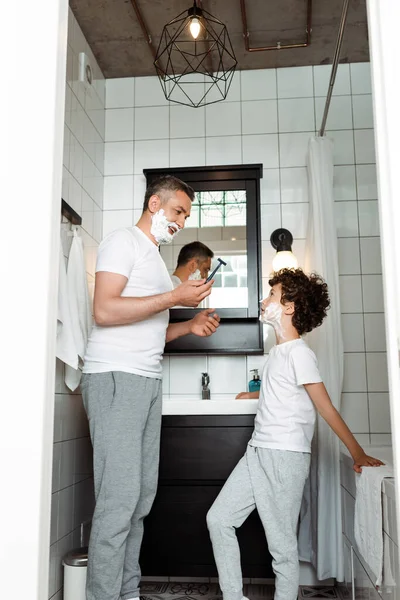 Handsome Father Shaving Foam Face Holding Razor Curly Son — Stock Photo, Image