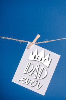 White greeting card with best dad ever illustration hanging on rope with clothespins isolated on blue clipart