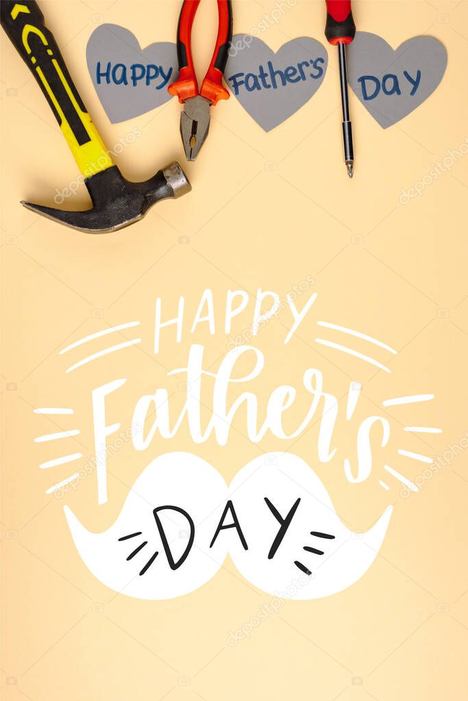 top view of hammer, screwdriver, pliers and grey paper hearts on beige background, happy fathers day illustration