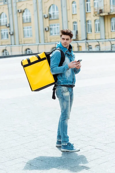 Side View Delivery Man Thermo Backpack Holding Smartphone Urban Street — Stock Photo, Image