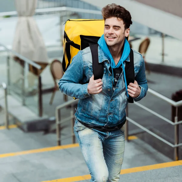 Schöner Kurier Mit Thermorucksack Lächelt Beim Treppensteigen Auf Der Stadtstraße — Stockfoto