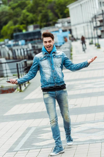 Homem Alegre Fones Ouvido Segurando Smartphone Sorrindo Para Câmera Rua — Fotografia de Stock