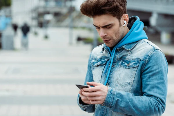 Knappe Man Koptelefoon Met Behulp Van Smartphone Stedelijke Straat — Stockfoto