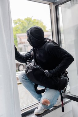 Soyguncunun seçici odak noktası kar maskesi ve cam kenarında duran deri eldivenler. 
