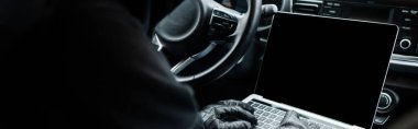 Panoramic crop of robber using laptop in car  clipart