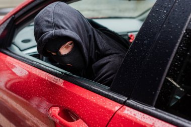 Kar maskeli soyguncunun seçici odak noktası arabada otururken gözlerini kaçırması. 