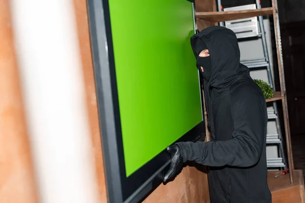 盗匪盗窃案中戴着面具 手持电视机的选择性焦点 — 图库照片