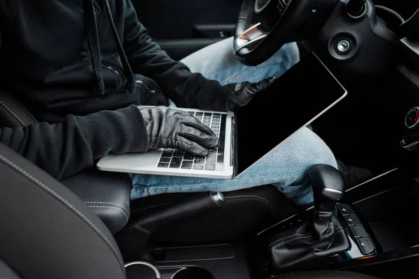Ausgeschnittene Ansicht des Diebes in Lederhandschuhen mit Laptop mit leerem Bildschirm im Auto — Stockbild Ausgeschnittene Ansicht Des Diebes Lederhandschuhen Mit Laptop Mit Leerem Bildschirm — Stockfoto