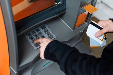 Kredi kartı tutarken ATM 'yi kullanan hırsızın görüntüsü 