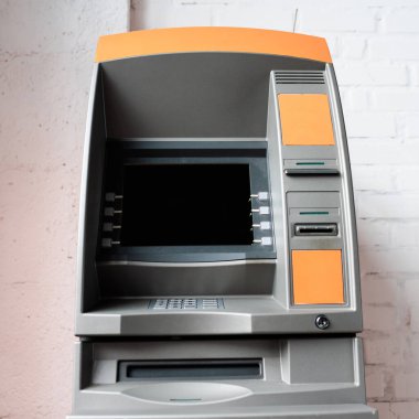 Beyaz tuğla duvarın yanında boş ekranlı ATM