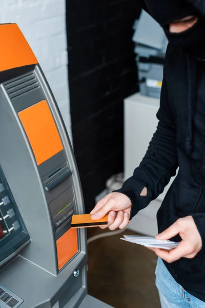 Selective Focus Thief Balaclava Using Atm While Holding Credit Cards — Stock Photo, Image