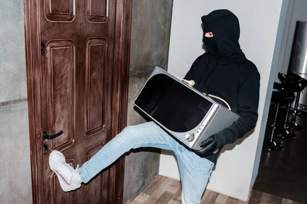 Ladrón Máscara Sosteniendo Microondas Cerrando Puerta Casa Durante Robo —  Fotos de Stock