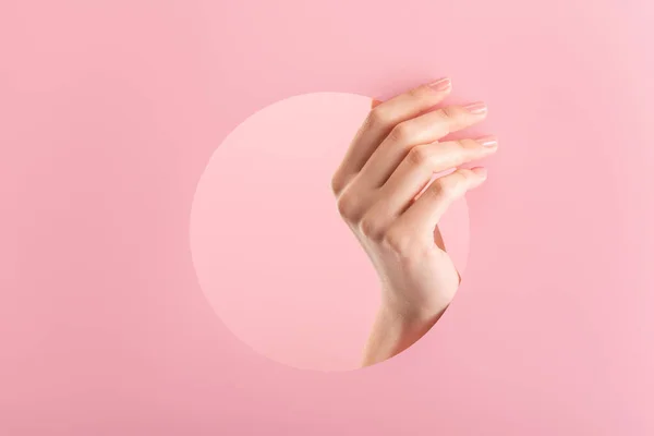 Bijgesneden Weergave Van Vrouwelijke Hand Papier Rond Gat Geïsoleerd Roze — Stockfoto