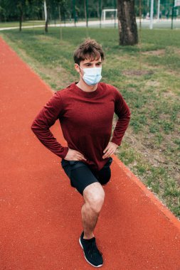 Sağlık maskeli sporcu parkta koşuya çıkıyor. 