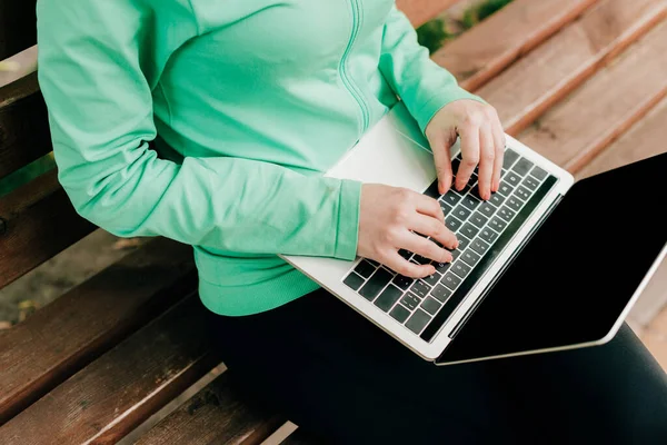 Kentteki bankta dizüstü bilgisayar kullanan serbest çalışanın görüntüsü. 