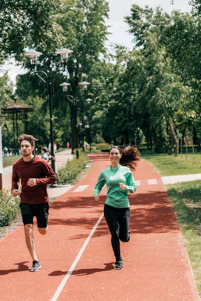 Bonito Homem Correndo Perto Namorada Positiva Caminho Corrida Parque — Fotografia de Stock