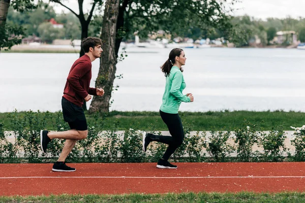 Vista Lateral Pareja Corriendo Pista Atletismo Parque — Foto de Stock