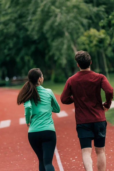 Parktaki Koşu Yolunda Erkek Arkadaşının Yanında Koşan Sporcu Kadının Arka — Stok fotoğraf