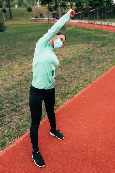 Mujer Joven Con Máscara Médica Haciendo Ejercicio Pista Atletismo Parque — Foto de Stock