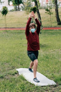 Sağlık maskeli sporcu. Parkta spor paspası eğitimi almış. 