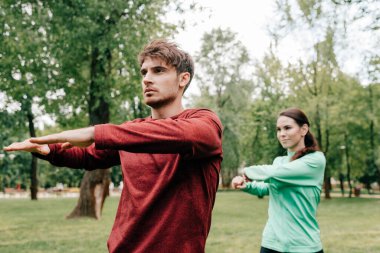 Sporcunun seçici odak noktası parkta kız arkadaşının yanında ısınması. 