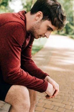 Parkta dinlenen yakışıklı sporcunun yan görüntüsü 