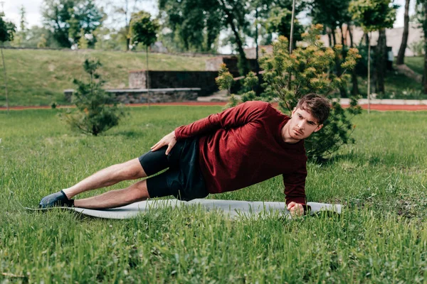 Enfoque Selectivo Deportista Guapo Haciendo Tablón Lateral Mientras Entrena Estera — Foto de Stock