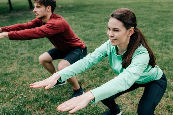 Selective Focus Smiling Sportswoman Doing Squat While Working Out Boyfriend — Stock Photo, Image