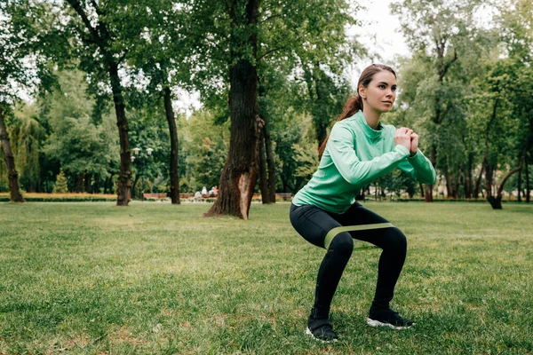 Attractive Sportswoman Doing Squat Resistance Band Park — Stock Photo, Image