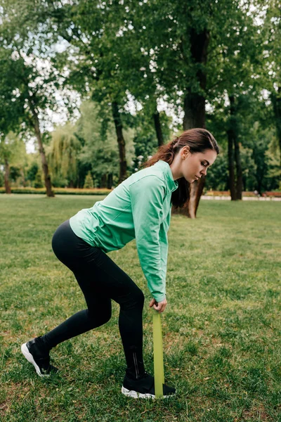 Side View Sportswoman Pulling Resistance Band Park — стоковое фото