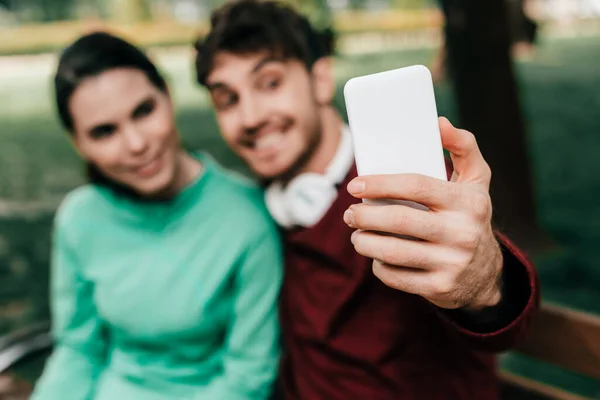 Parkta Akıllı Telefonla Konuşan Gülümseyen Çiftin Seçici Odak Noktası — Stok fotoğraf