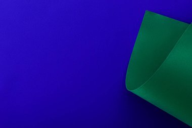mavi arkaplanda yeşil renkli kıvrımlı kağıt
