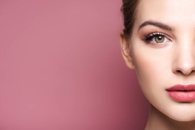 Pembe üzerine izole edilmiş kameraya bakan genç bir kadın görüntüsü. 