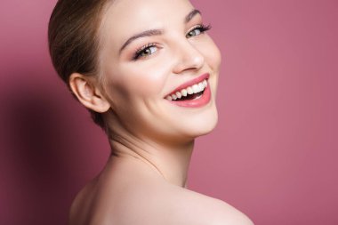 Çıplak ve mutlu kadın makyajlı pembe üzerine gülüyor. 