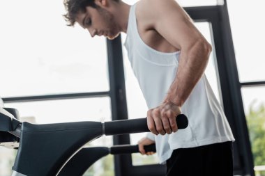 Koşu bandında tırabzanlara dokunan yorgun sporcunun seçici odağı 