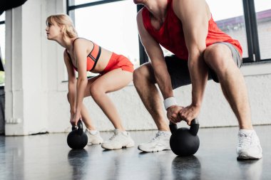 Spor salonundaki ağır dambıllarla egzersiz yapan çiftlerin seçici odağı. 